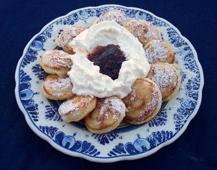 Plate of Dutch poffertjes dusted with icing sugar